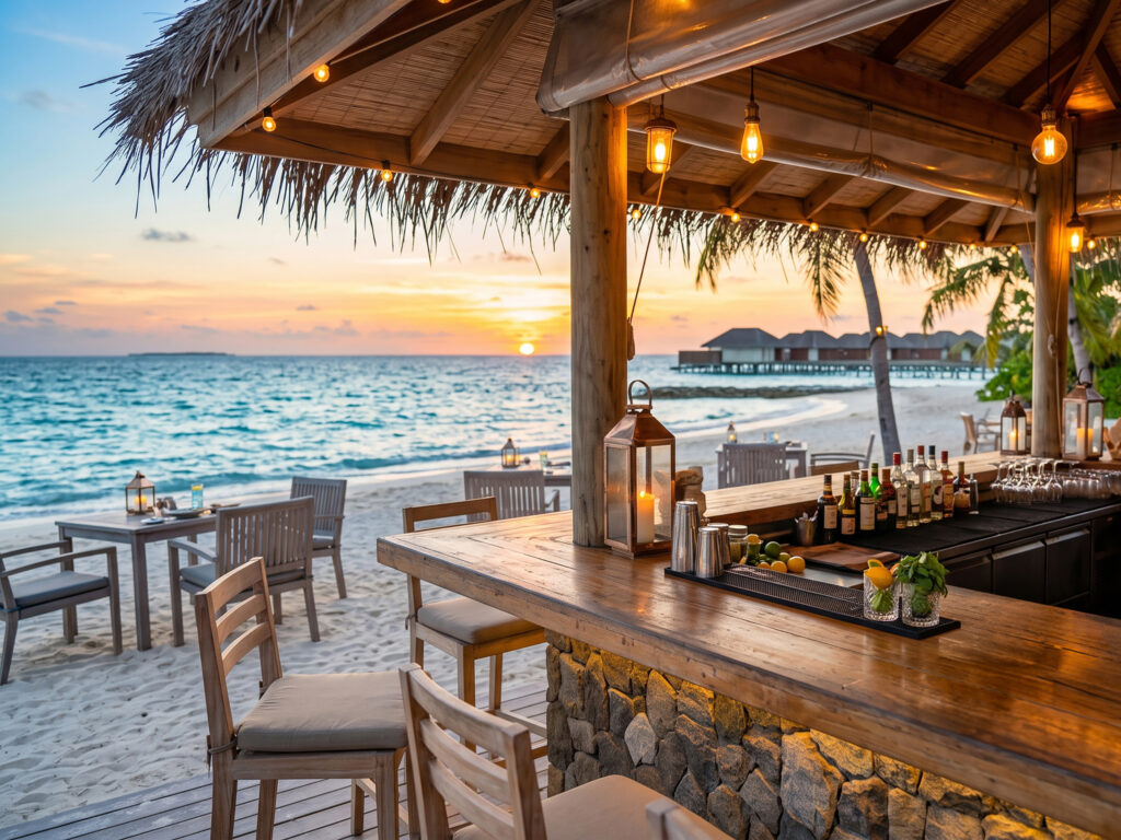 Beachfront Sunset Bar Thatched-roof beachfront bar with aligned bottles and hanging glassware overlooking the ocean at sunset