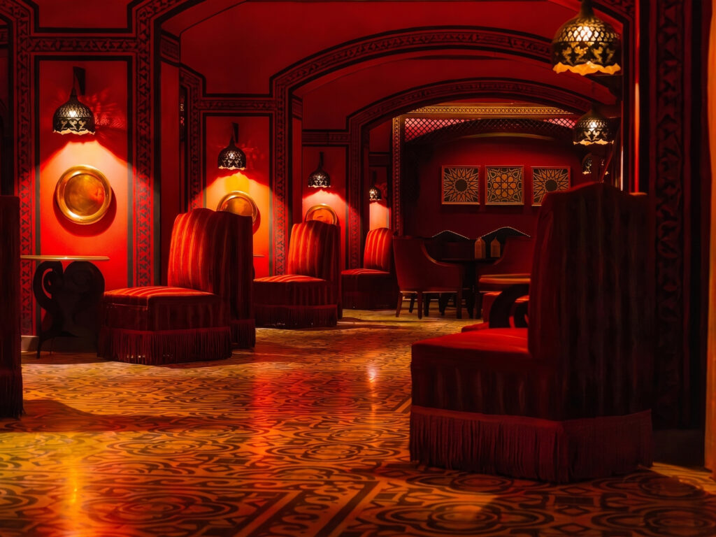 Opulent Lounge Seating Richly upholstered red velvet lounge seating beneath ornate pendant lanterns in a dimly lit lounge