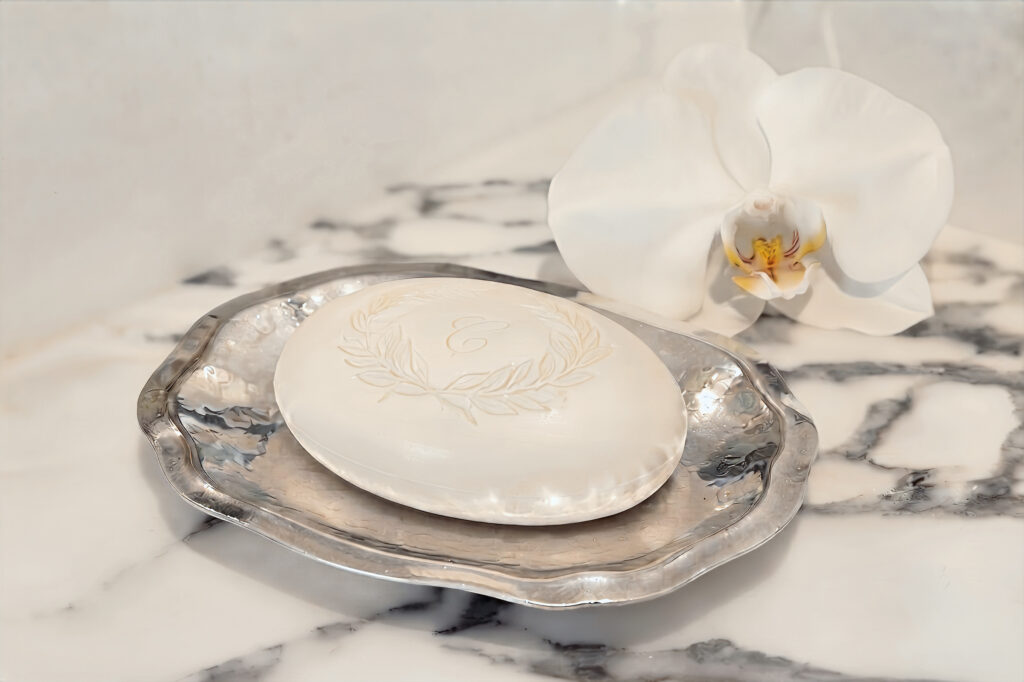 Monogrammed Soap Detail with Orchid Macro detail of a monogrammed hotel soap bar on a hammered silver tray with a white orchid blossom